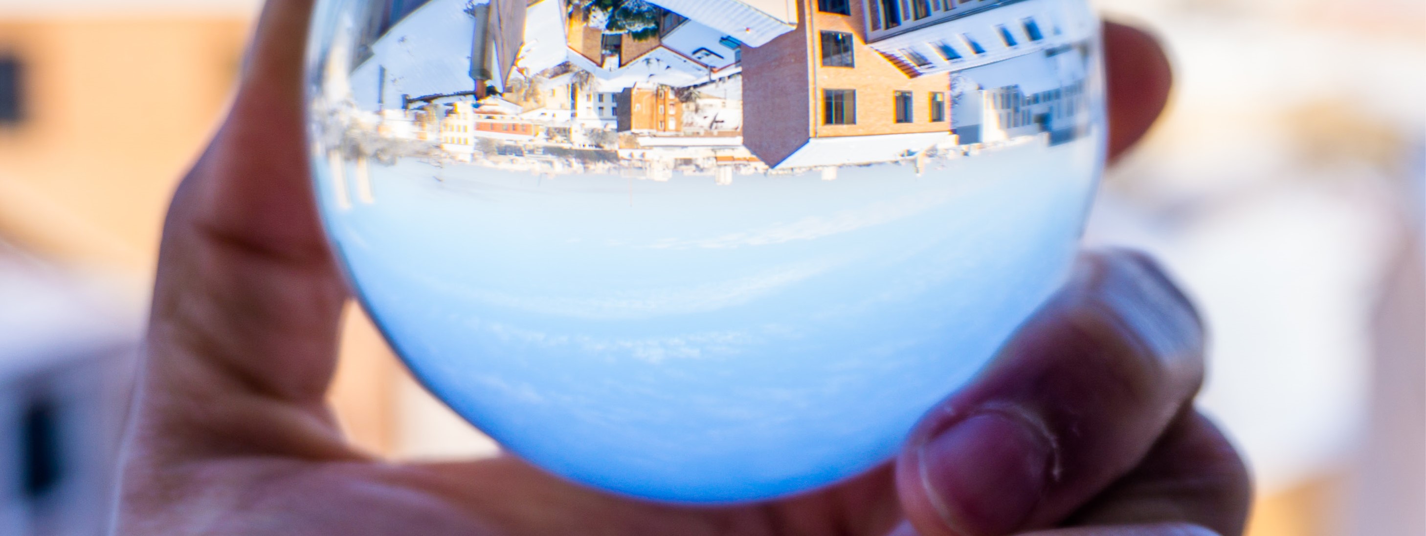 Glaskugel in einer Hand spiegelt die Umgebung verkehrtherum